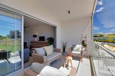 a living room with a couch and chairs on a balcony at Apartamento Vista Jardim by Portucasa in Albufeira