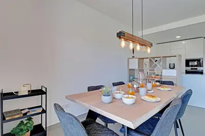 a dining room table with blue chairs in a kitchen at Apartamento Vista Jardim by Portucasa in Albufeira