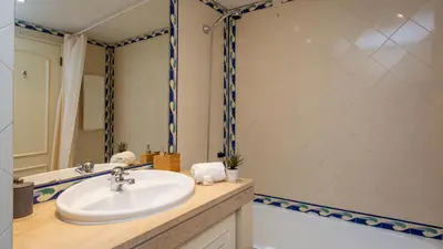 a bathroom with a sink and a bath tub at Marina 2BDR Apartment With Balcony & Pool - 5min from beach by LovelyStay in Quarteira