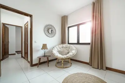 a living room with a chair and a window at APARTAMENTO TROPICANA in Quarteira