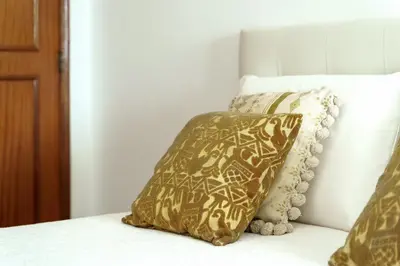 a brown and white pillow sitting on a bed at APARTAMENTO TROPICANA in Quarteira