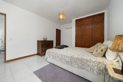 a bedroom with a bed and a dresser in it at APARTAMENTO TROPICANA in Quarteira