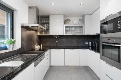 a white kitchen with white cabinets and a sink at Apartamento Janelas Oceano - Vilamoura in Quarteira