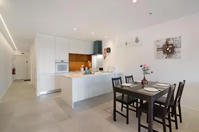 a kitchen and dining room with a table and chairs at Apartamento Max Tropical by Sunnyway in Albufeira