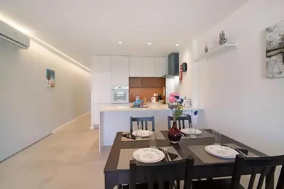 a kitchen and dining room with a table and chairs at Apartamento Max Tropical by Sunnyway in Albufeira