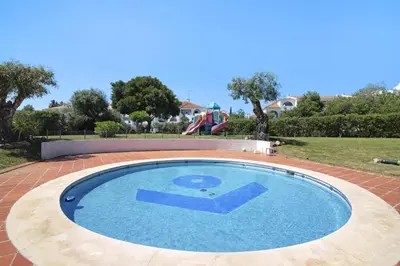 a small swimming pool with a playground in the background at Apartamento Max Tropical by Sunnyway in Albufeira