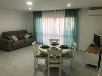 a living room with a table and chairs and a couch at Bmar in Quarteira