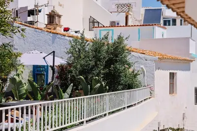 a white balcony with plants and buildings at Old Fisherman's Corner 14 - Centro Old Town Albufeira in Albufeira