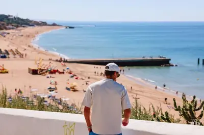 a man standing on a wall looking at a beach at Old Fisherman's Corner 10 - Centro Old Town Albufeira in Albufeira