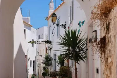 an alley with white buildings and a palm tree at Old Fisherman's Corner 10 - Centro Old Town Albufeira in Albufeira