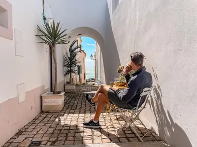 a man sitting at a table in a chair at Old Fisherman's Corner 12 - Centro Old Town Albufeira in Albufeira