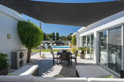 a patio of a house with a table and chairs at Villa Allegra - Quinta do Lago in Almancil