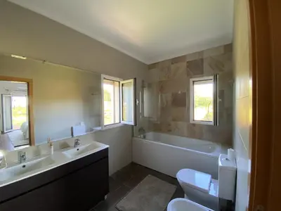 a bedroom with a white bed and a red wall at Charming Villa with pool close to Faro Portugal