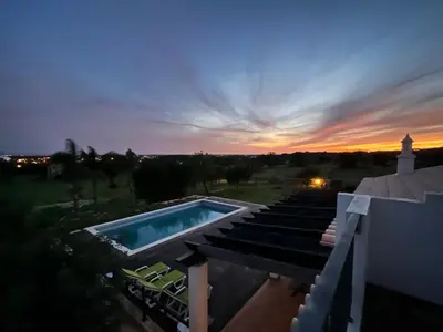 a table with two glasses and a bottle of wine at Charming Villa with pool close to Faro Portugal