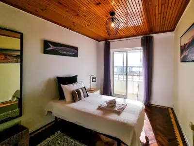 a bedroom with a large bed with a window at FLH Faro Family Flat with Balcony in Faro