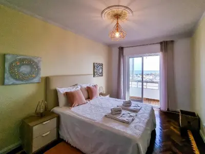 a bedroom with a bed with pink pillows and a window at FLH Faro Family Flat with Balcony in Faro