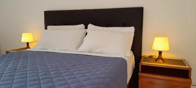 a bedroom with a bed with a blue comforter and two lamps at CASA IRINA Centro Cidade Albufeira in Albufeira