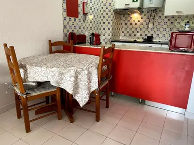 a table and chairs in a kitchen with a red counter at CASA IRINA Centro Cidade Albufeira in Albufeira