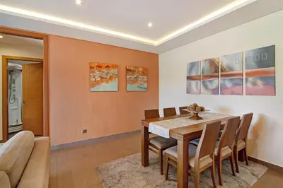 a dining room with a wooden table and chairs at Varandas do Sol - Olhos de Água in Albufeira