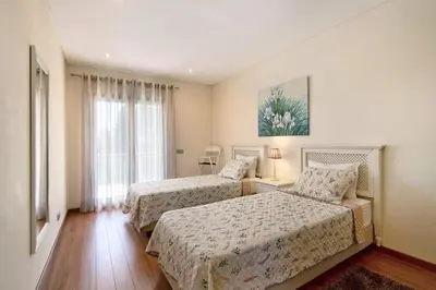 a bedroom with two beds and a window at Varandas do Sol - Olhos de Água in Albufeira