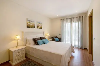 a bedroom with a bed with a white bedspread at Varandas do Sol - Olhos de Água in Albufeira