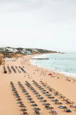 a large swimming pool with chairs and a building at Estúdio Solar A by MTPhomes in Albufeira