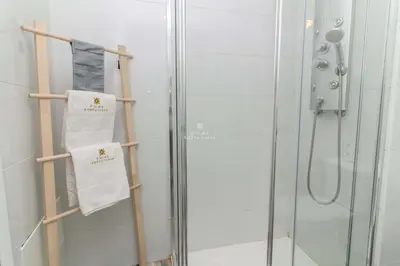 a bathroom with a shower and two towels on a rack at Aveiros Beach Apartment Ocean View - By Dalma Portuguesa in Albufeira