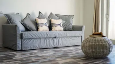 a couch with pillows on it in a living room at Aveiros Beach Apartment Ocean View - By Dalma Portuguesa in Albufeira