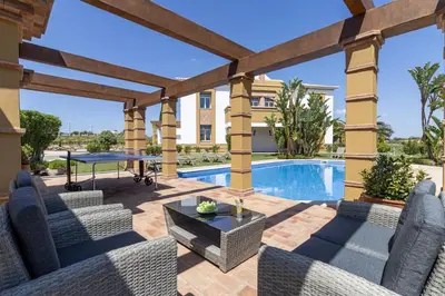 a patio with a table and chairs and a pool at Quinta Dionysus in Albufeira