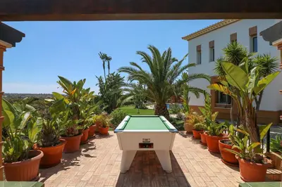 a pool table in a courtyard with potted plants at Quinta Dionysus in Albufeira