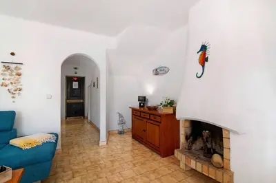 a living room with a fireplace and a blue couch at Apartamento São Rafael in Albufeira