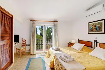 a bedroom with a bed and a large window at Apartamento São Rafael in Albufeira