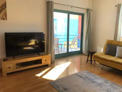 a living room with a flat screen tv and a couch at Marina View Apartment in Albufeira