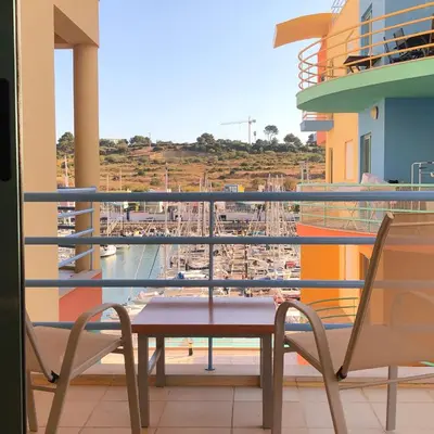 a table and chairs on a balcony with a marina at Marina View Apartment in Albufeira