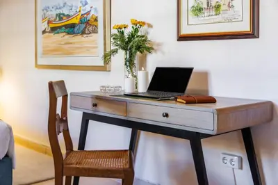 a desk with a laptop computer on top of it at Villa Tranberg Suites in Ferreiras