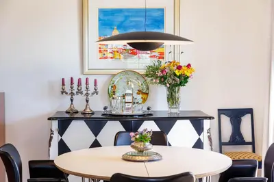 a dining room with a table and a pendant light at Villa Tranberg Suites in Ferreiras