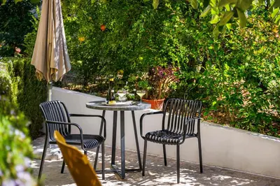 a table and two chairs and an umbrella on a patio at Villa Tranberg Suites in Ferreiras