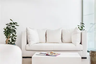 a white couch in a living room with a coffee table at Vila Maria Hotel - Adults Only in Albufeira