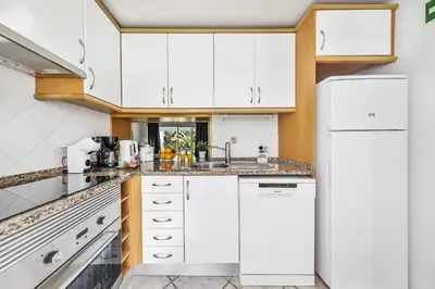 a kitchen with white cabinets and a white refrigerator at Vista Portuguesa by OCvillas in Albufeira