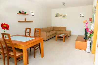 a living room with a table and a couch at Villa facing the pool by Algarve Dream Holidays in Fontainhas