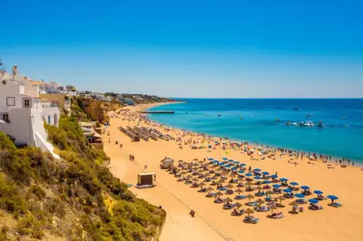 a beach with many umbrellas and people on it at Villa facing the pool by Algarve Dream Holidays in Fontainhas