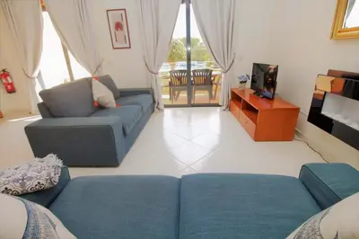a living room with two blue couches and a television at Apartment Garcas Lounge - By Dalma Portuguesa in Albufeira