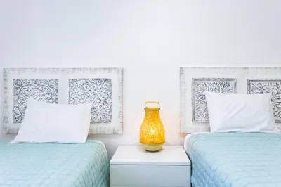 a bedroom with two beds and a vase on a night stand at Vilar do Jardim - Terrace and Pool - Vilamoura in Quarteira