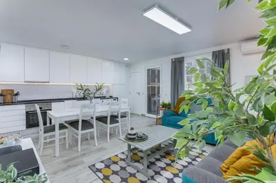 a kitchen and a living room with a couch and a table at Vilar do Jardim - Terrace and Pool - Vilamoura in Quarteira