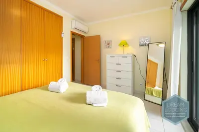 a bedroom with a bed and a dresser and a mirror at Vista das Ondas 02B - Dream Lodging in Albufeira