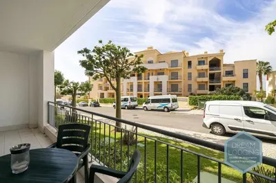 a balcony with a table and chairs and a building at Vista das Ondas 02B - Dream Lodging in Albufeira