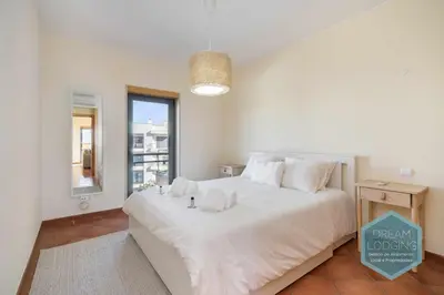 a bedroom with a large white bed with a window at Oceanus Jardim - Dream Lodging in Albufeira