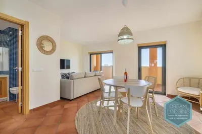 a dining room and living room with a table and chairs at Oceanus Jardim - Dream Lodging in Albufeira