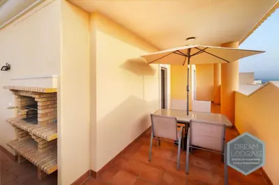 a dining room with a table and an umbrella at Oceanus Jardim - Dream Lodging in Albufeira