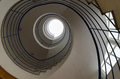 a spiral staircase with a round window in a building at Albufeira Apartment Pool & Tennis in Albufeira